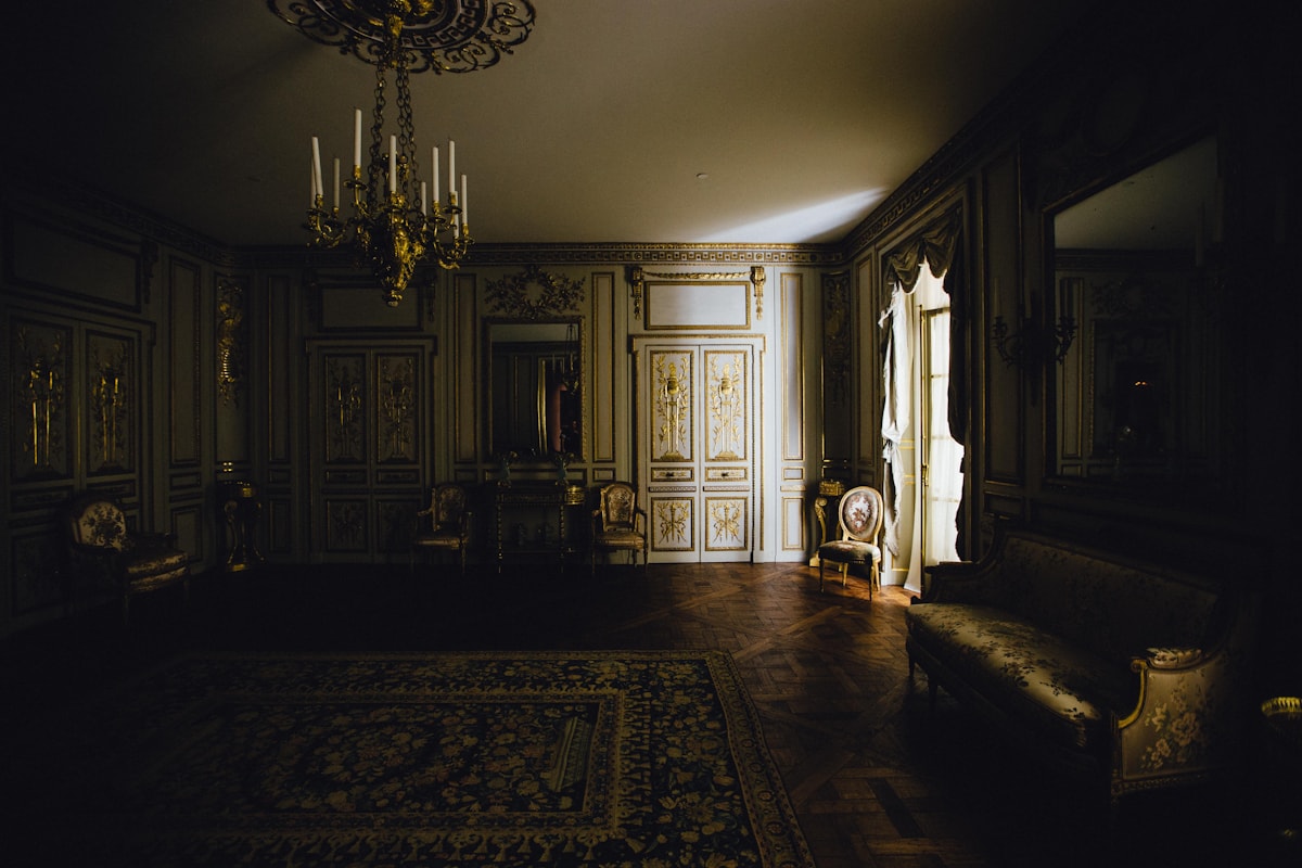 candlelit study with leather chairs and ivy on the bookshelves