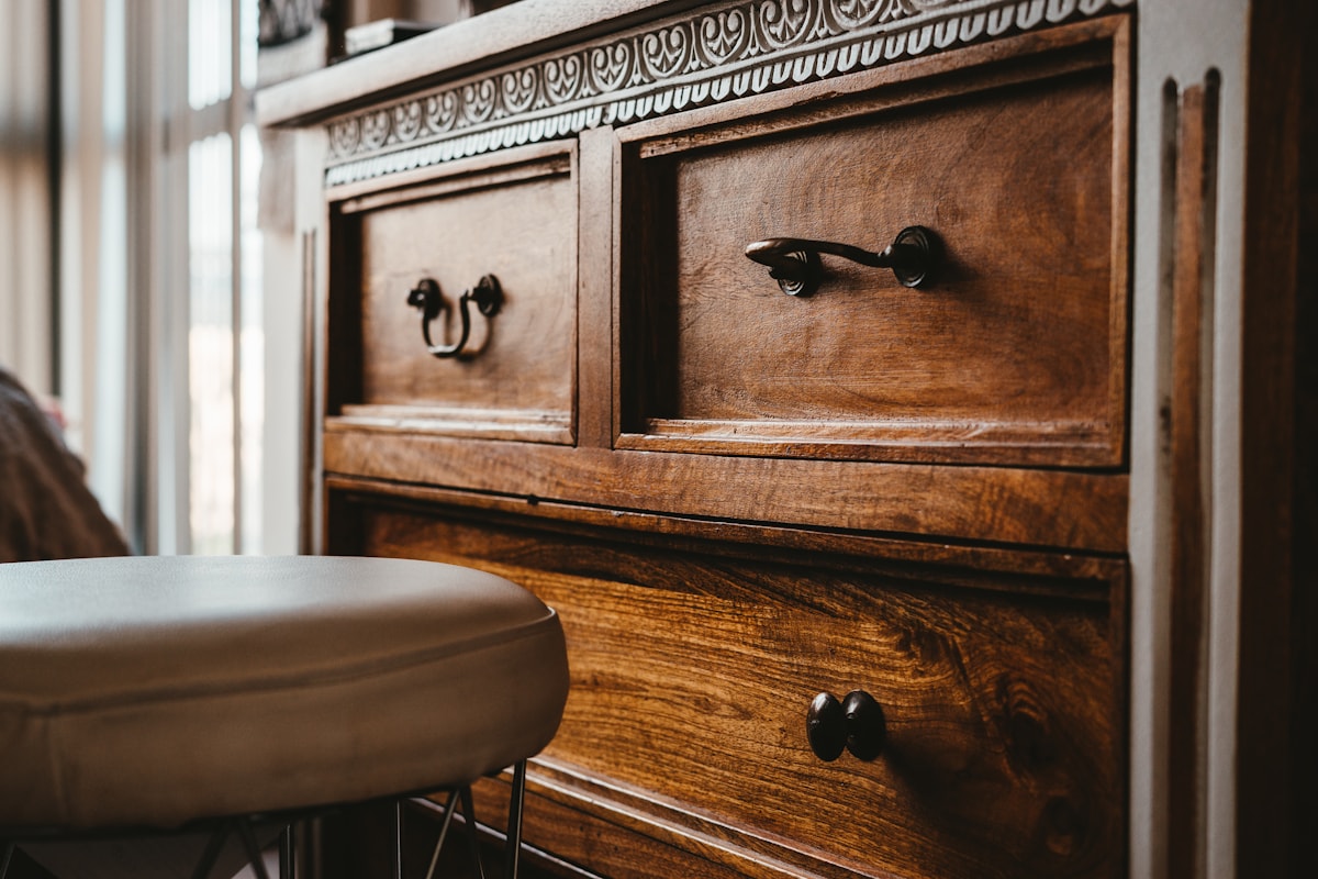 carved oak cupboard and a worn velvet armchair in a candlelit corner